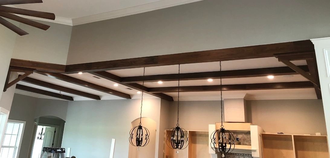 Dark box beams. Stained box beams across an open living space.