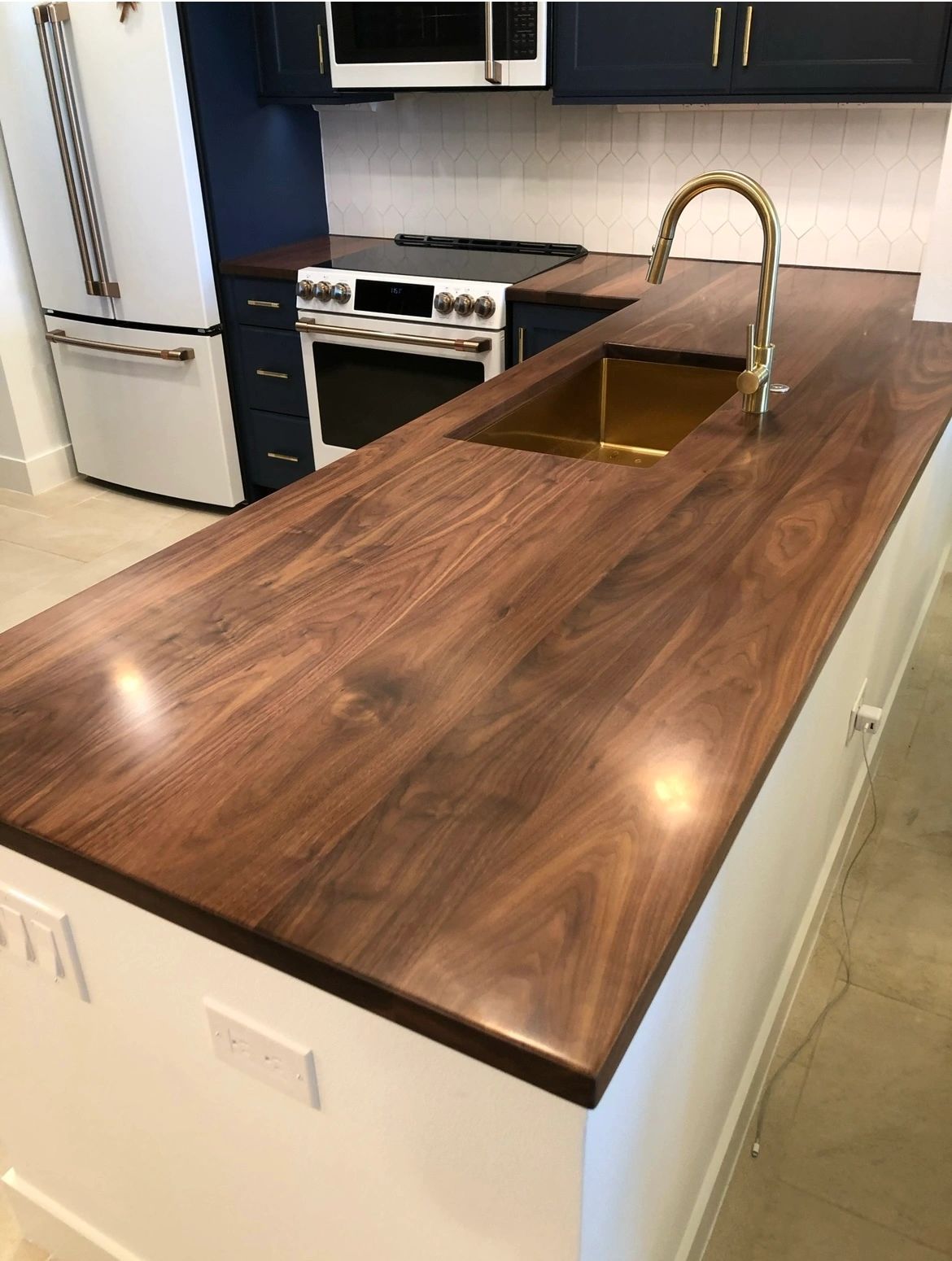 Walnut island, finished. Walnut against navy cabinets and white tile.